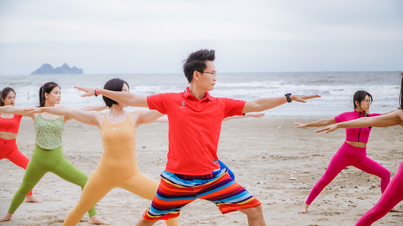 Huấn luyện viên Yoga Đặng Kim Ba dẫn một lớp tập trên biển với nhiều người ở các trình độ khác nhau