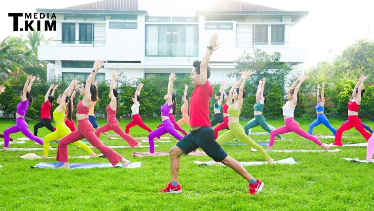 HLV Yoga Đặng Kim Ba dẫn một lớp tập Yoga đông học viên ngoài trời