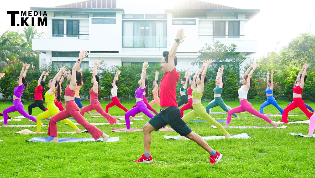 HLV Yoga Đặng Kim Ba dẫn một lớp tập Yoga đông học viên ngoài trời