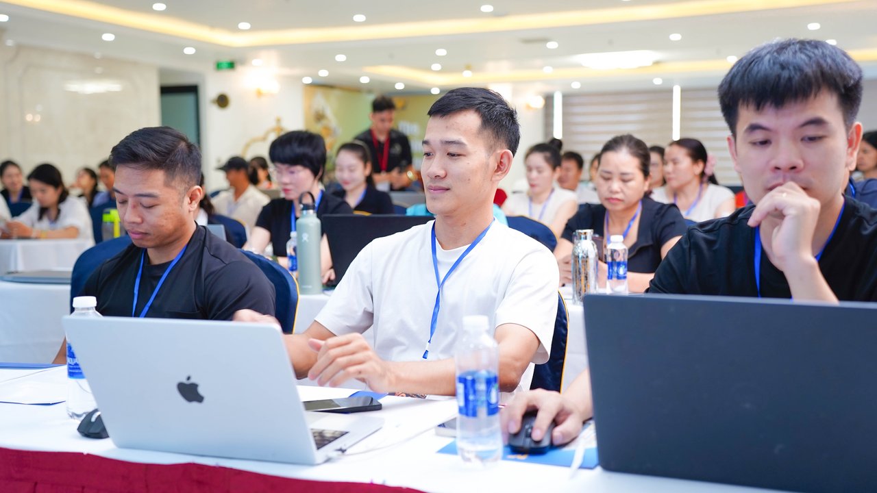 Các huấn luyện viên Yoga thực hành ứng dụng AI trên laptop tại sự kiện của Kim Ba Yoga