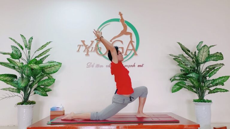Đặng Kim Ba trong tư thế chùng chân thấp, hai tay đưa lên cao, tại Học viện Yoga T.Kim
